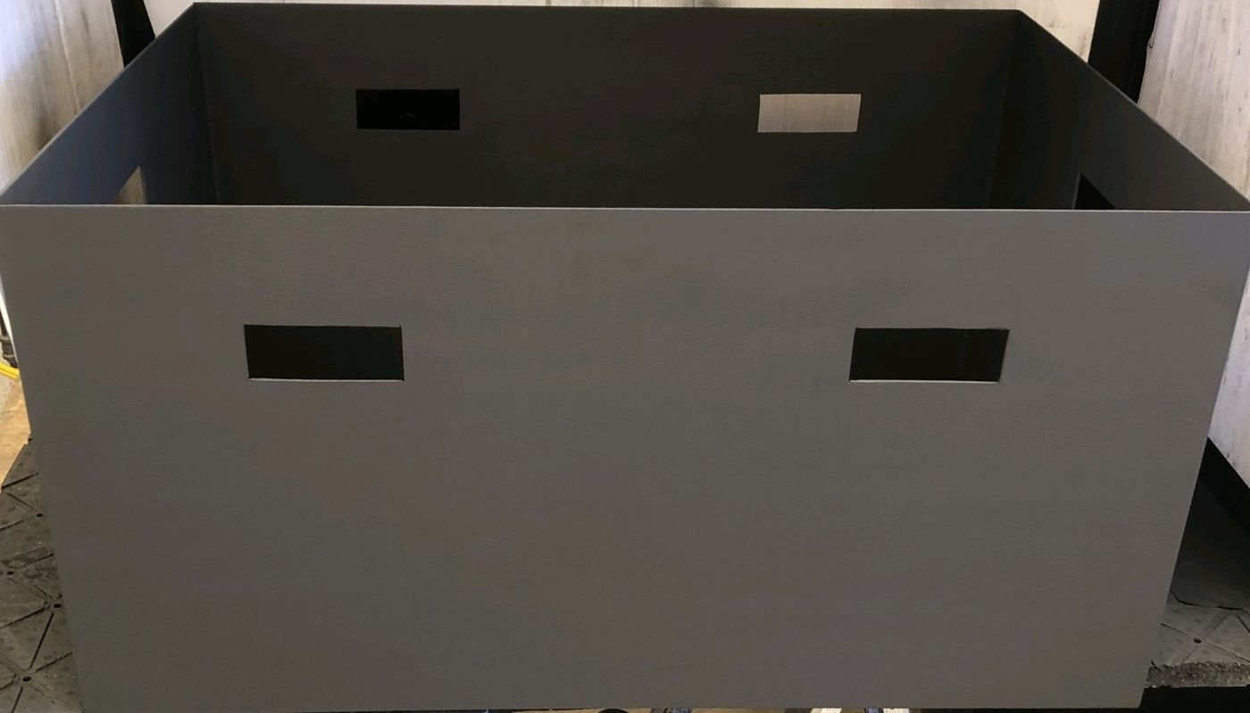 Welded gray square steel fire pit with cut hand-slots