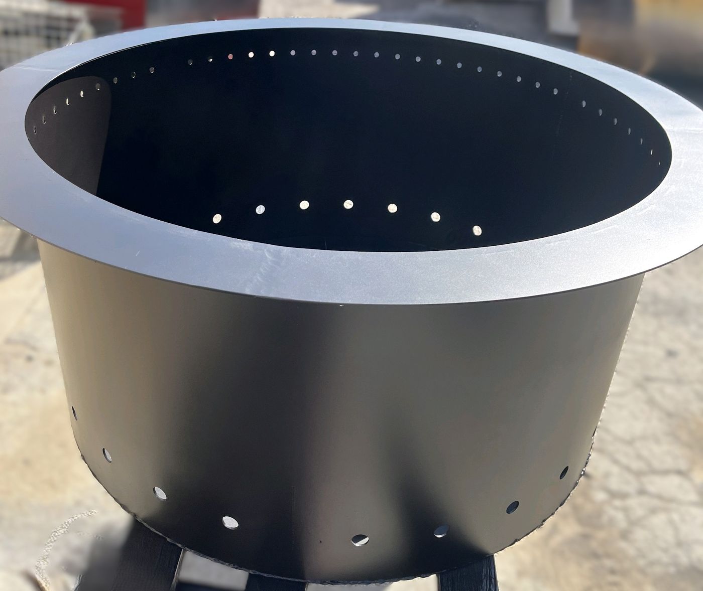 Double-wall-style fire pit with intake holes around the rim and base
