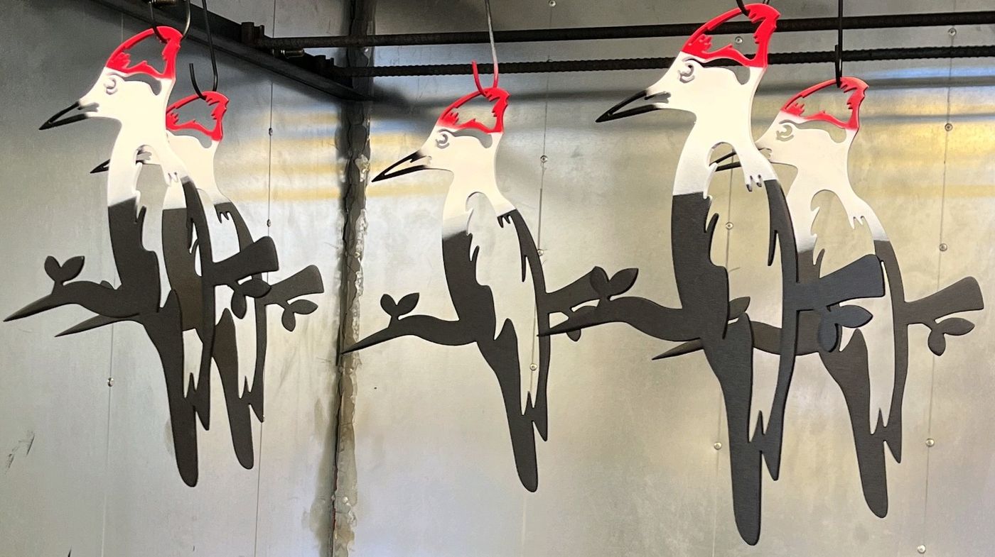 Plasma-cut pileated woodpeckers in multi-color powder coat