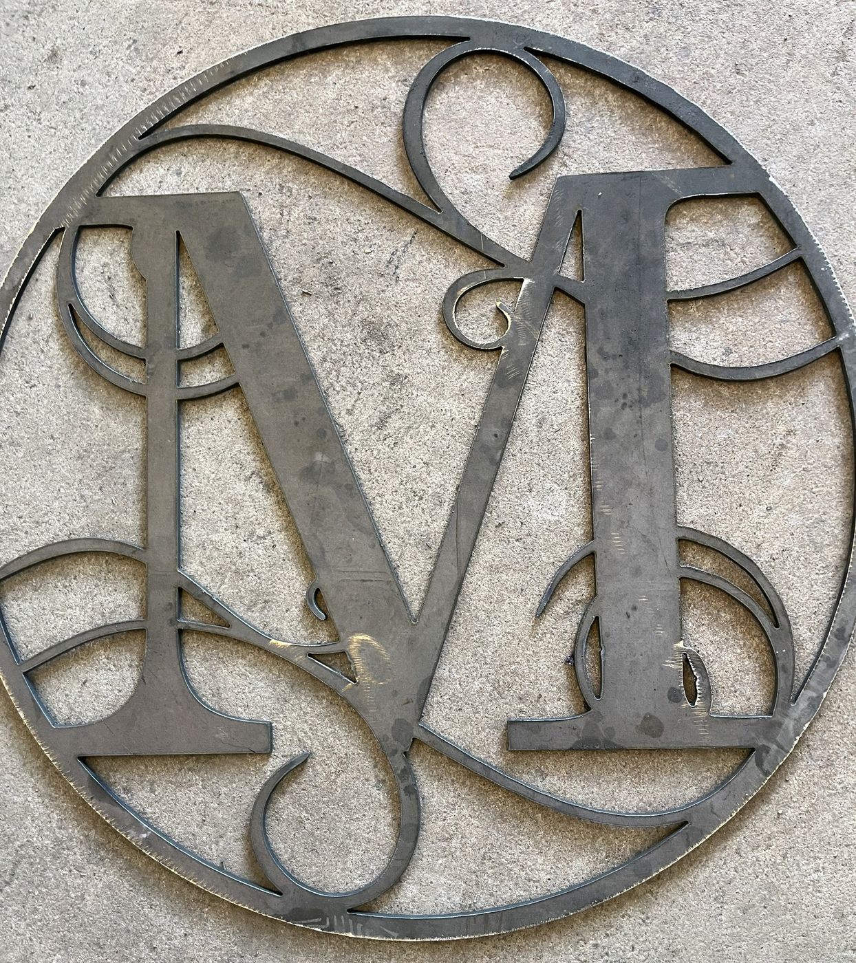 Scrolled M monogram in a circular border