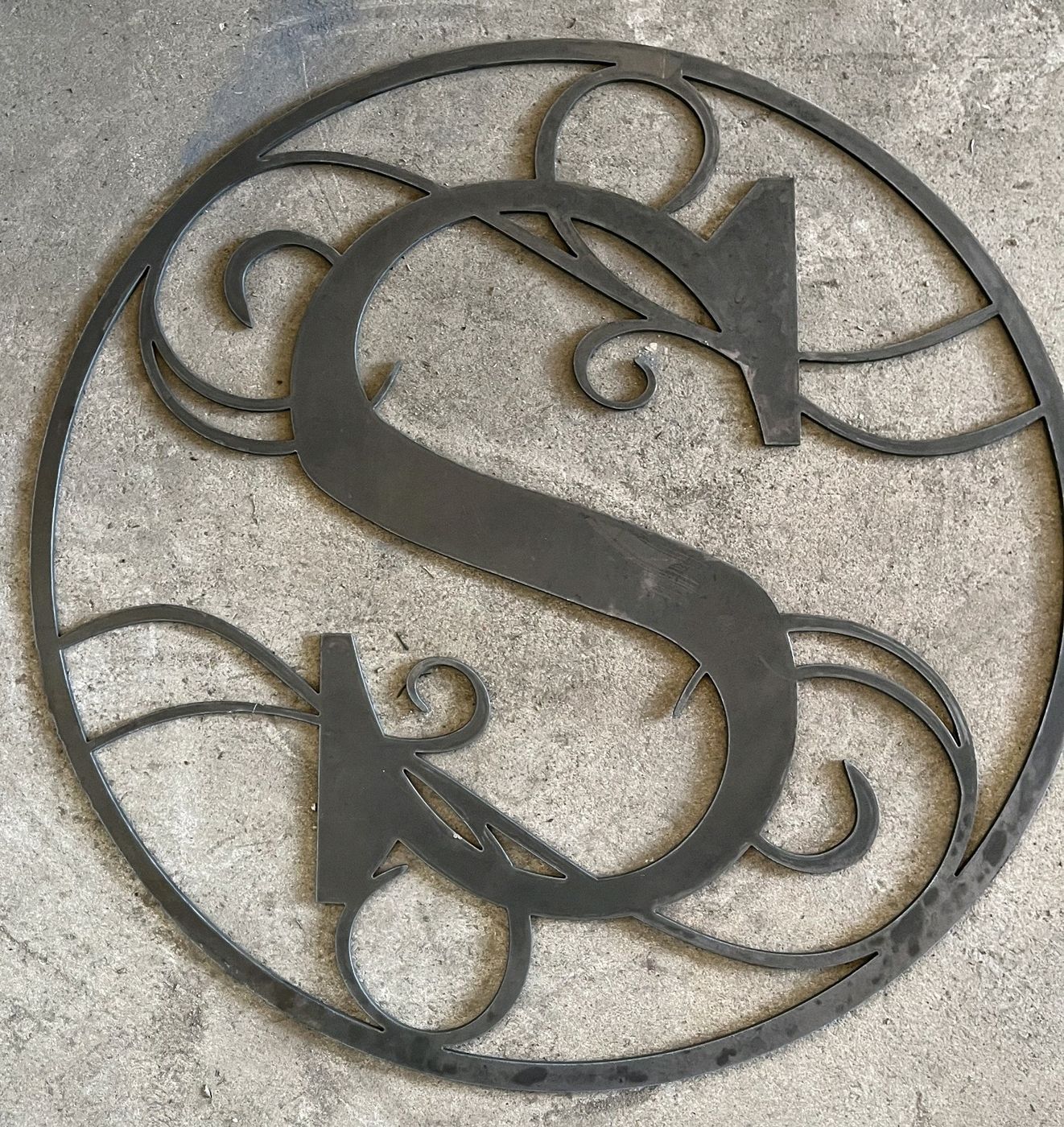 Decorative S monogram inside a scrolled ring, plasma-cut from plate