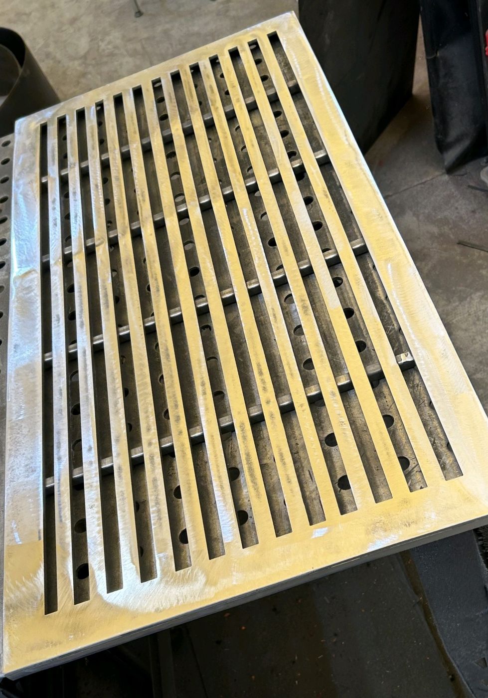 Heavy slotted steel grate finished flat
